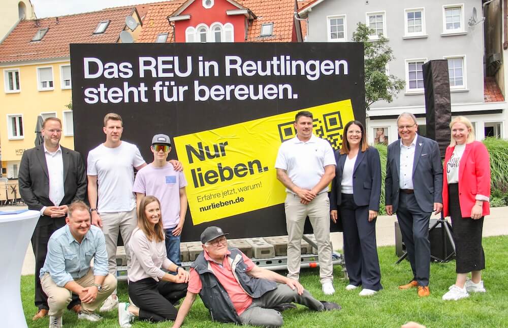 destinationsmanagement-reutlingen-nur-lieben-stadtmanufaktur-magazin-2 Verantwortliche der Kampagne Nur lieben in Reutlingen vor einem Plakat in der Stadt