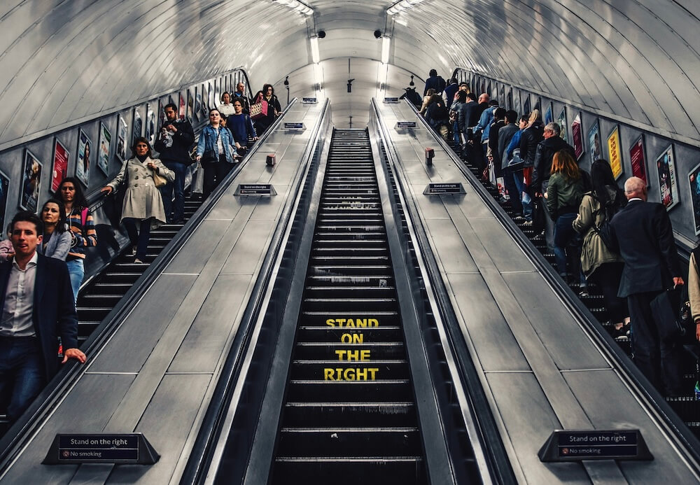 nudging-rolltreppe-stand-on-the-right Menschen auf einer Rolltreppe, mittig der Hinweis: Stand on the right.