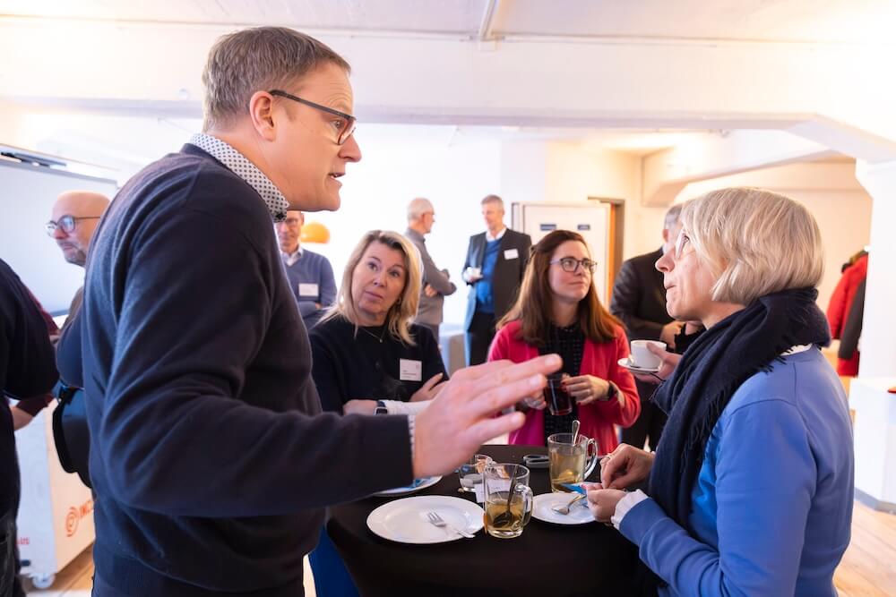Teilnehmende diskutieren angeregt in der Pause